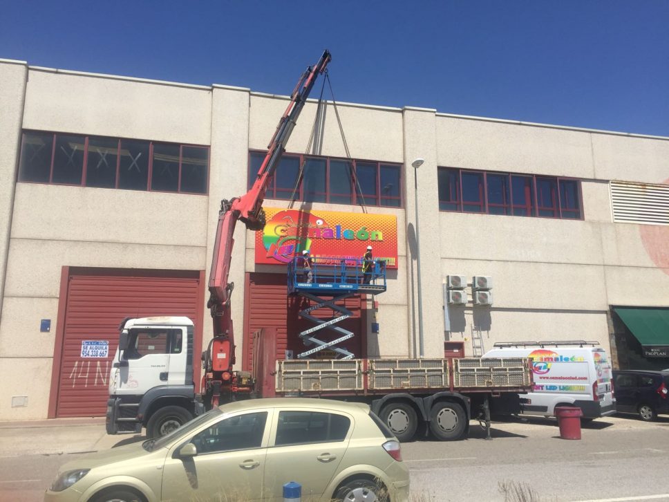 Camión 10.000 kg con grúa 45 tn colocando un cartel en Alcalá de Guadaíra