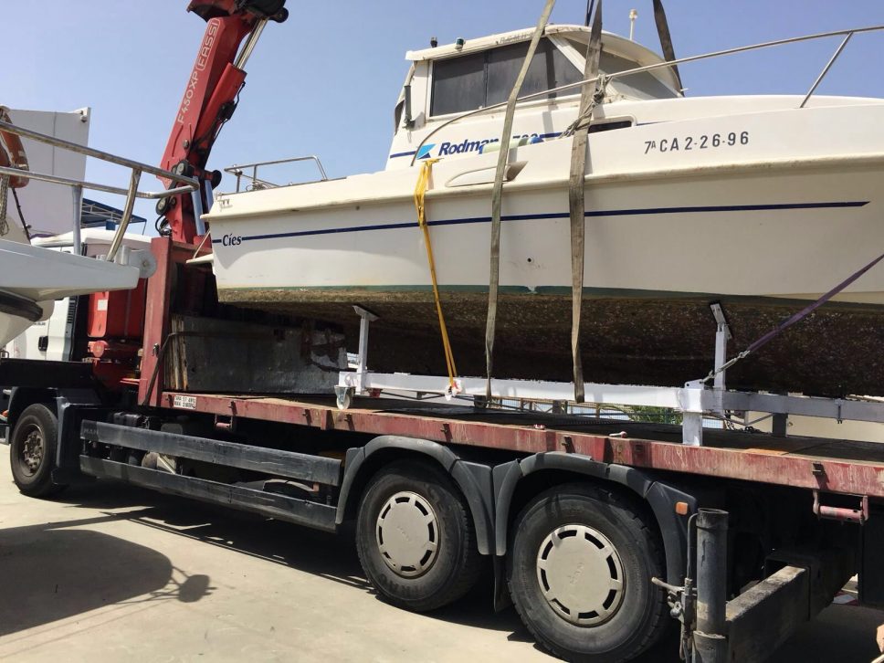 Camión con grúa de 45 tn cargando una embarcación de 3.400 kg para traslado desde Huelva a Sevilla con permiso de la DGT para poder transportar hasta 3 metros de anchura y 4,5 m. de altura