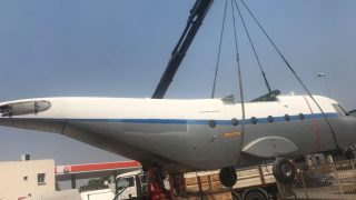 Camión 10000 kg grúa 80 tn cargando un avión en una góndola en La Rinconada